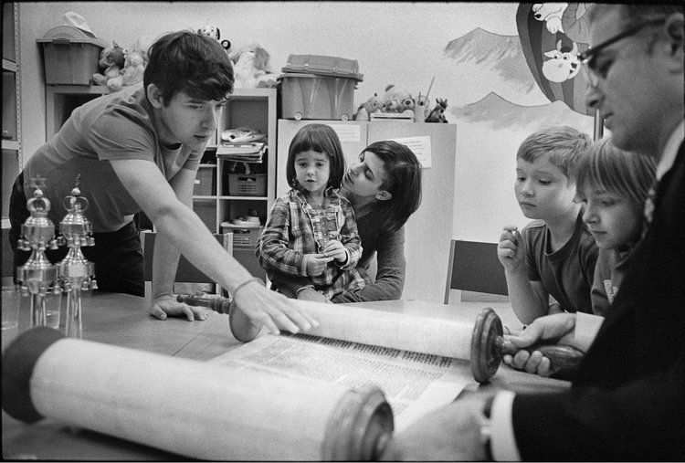 Jewish roots. Sept. 2013.Chuck Fishman, Newly-appointed American-Israeli Rabbi Avi Baumol (far right) introducing a Torah scroll to third- and fourth-generation post-Holocaust Jews. His first time teaching Sunday school at the Jewish Community Center (JCC). Krakow, 2013. © Chuck Fishman 