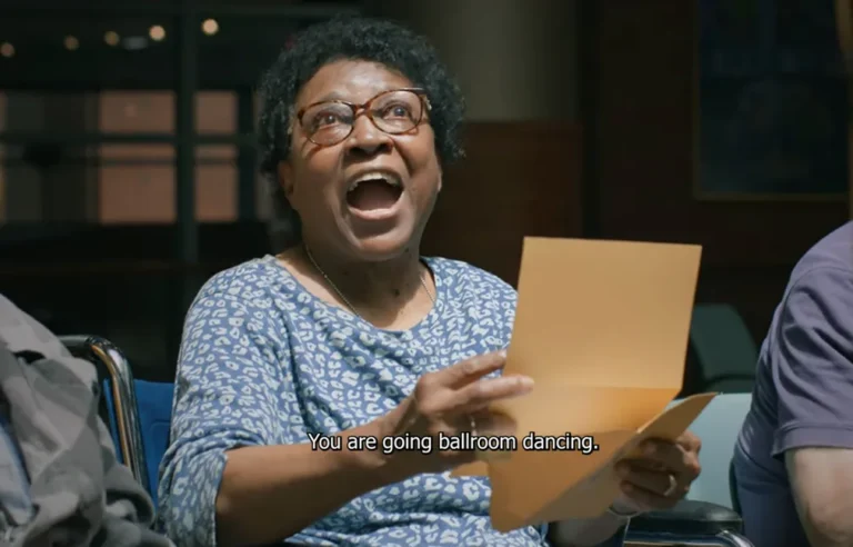 Smiling woman in glasses holds a paper. Subtitle reads: You are going ballroom dancing.